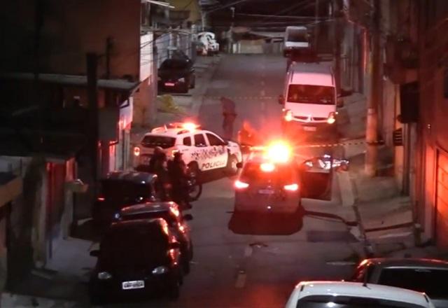 Movimentação de viatura policial, com giroflex ligado, em rua, durante a noite