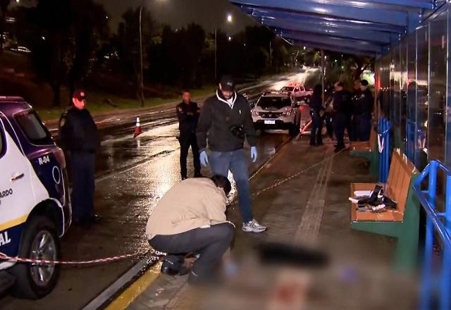 Movimentação policial em cena de crime, registrada em ponto de onibus