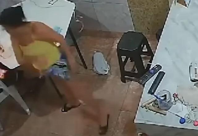 Mulher ao lado de balcão, com chama saindo de homem incendiado, que não aparece na imagem