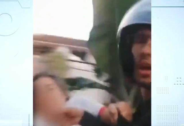 Mulher branca agredindo rapaz branco, de capacete, durante entrega de produto