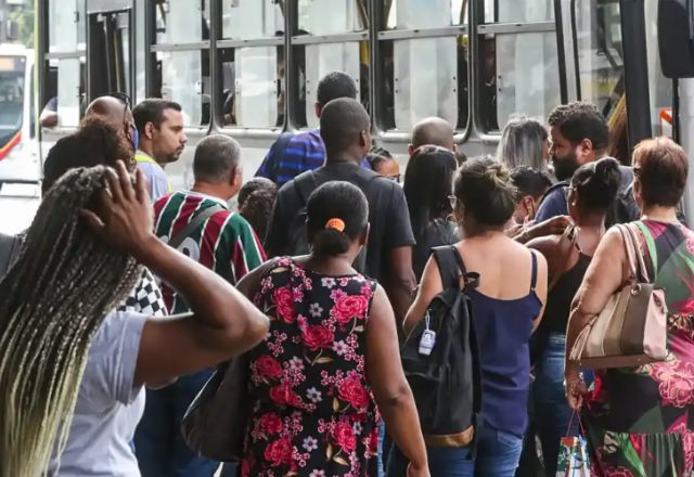 Mulher coça a cabeça em ponto de ônibus | Foto: Tânia Rego/Agência Brasil