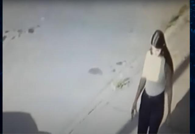 Mulher de camiseta branca e calça andando em estacionamento