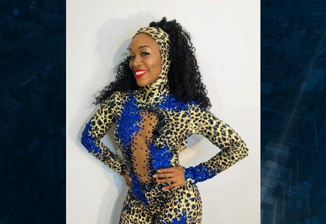 Mulher negra com fantasia tradicional de carnaval colada ao corpo, sorrindo para foto