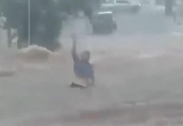 Mulher sendo levada por enxurrada durante temporal em Barretos, SP