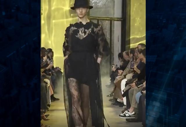 Mulheres desfilando com vestido preto e chapéu