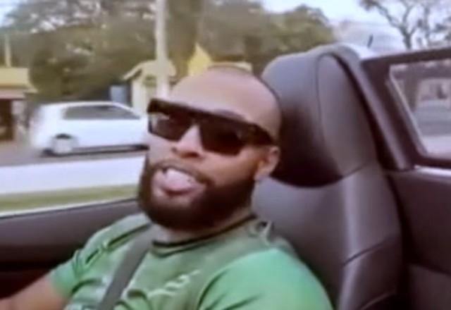 Nego Di usa camiseta e verde e está dirigindo carro conversível