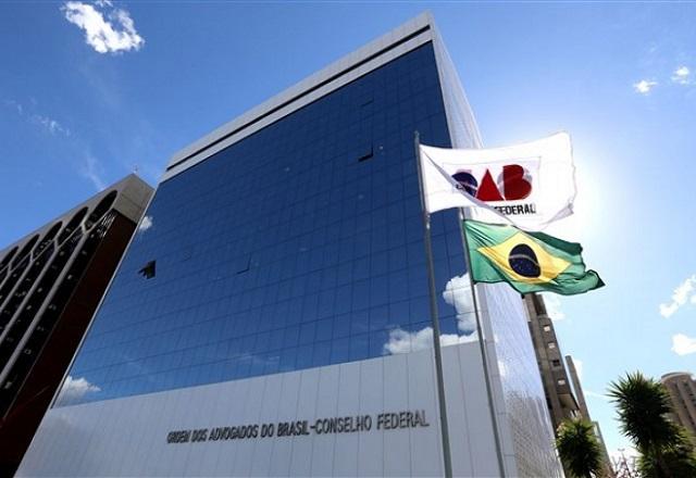 Bandeira da OAB e bandeira do Brasil hasteadas em frente a prédio da OAB Nacional (Divulgação/OAB-PB)