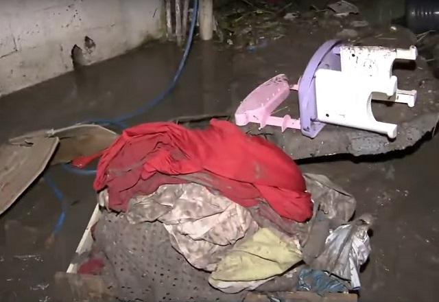 Objetos e móveis sujos e espalhados após água de chuva invadir residência