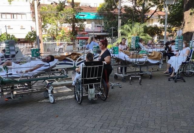 Pacientes em macas e cadeiras de rodas, ordenados em fila no meio da rua após incêndio em hospital