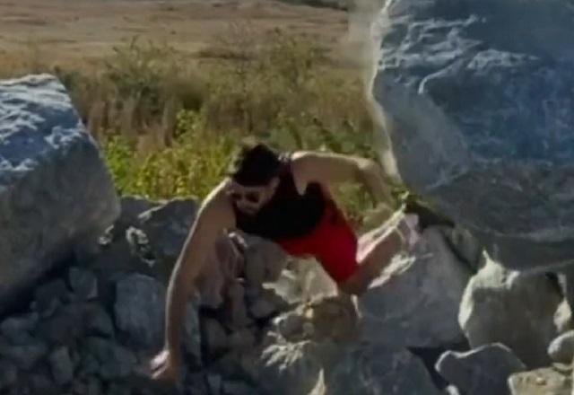 Pedra gigante prestes a rolar sobre homem branco, caindo antes do acidente