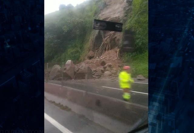 Pedras de grande porte após deslizamento, bloqueando rodovia em tempo chuvoso