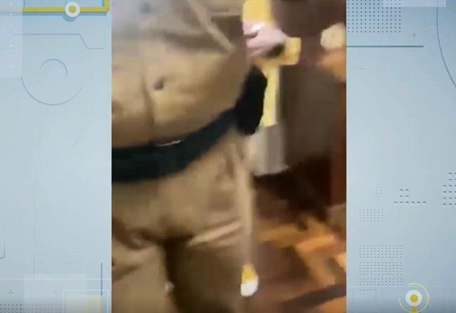 Pernas e cintura de policial militar, filmado por celular