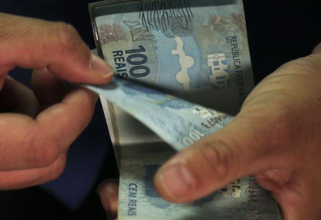 Pessoa conta cédulas de R$ 100
