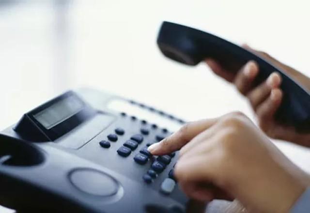 Pessoa discando em telefone fixo | Reprodução