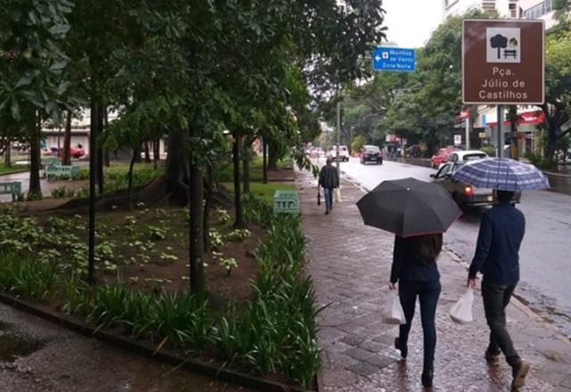 Pessoas caminhando segurando guarda-chuva durante tempestade
