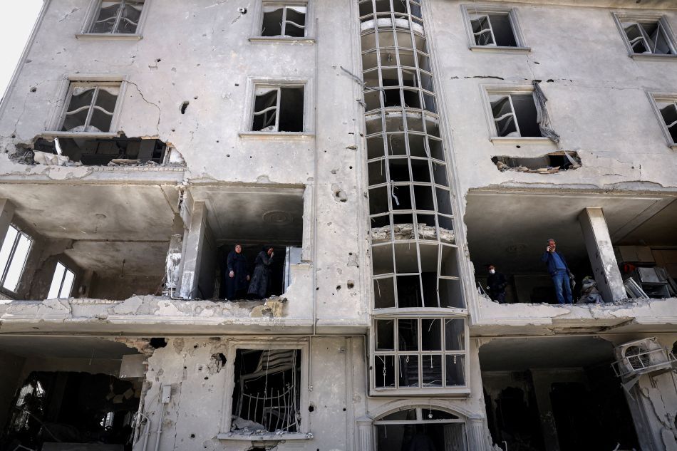 Pessoas inspecionam os danos em um prédio residencial após ser atingido por um ataque, em meio ao conflito entre EUA e Israel com o Irã, em Teerã | 30/03/2026/Majid Asgaripour/Wana (Agência de Notícias da Ásia Ocidental) via Reuters