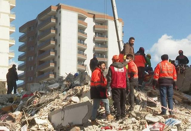 Pessoas sob escombros de terremoto, durante o dia