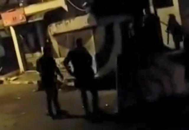 Policiais militares em beco escuro, durante a noite