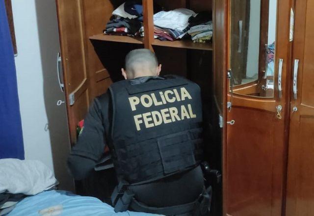 Policial Federal de costas fazendo procura
