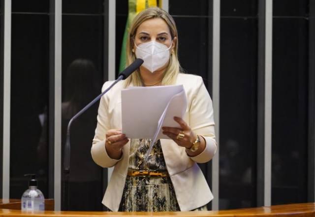 Policial Katia Sastre, relatora do projeto  do aumento de pena do feminicídio falando em plenário com documento na mão e máscara