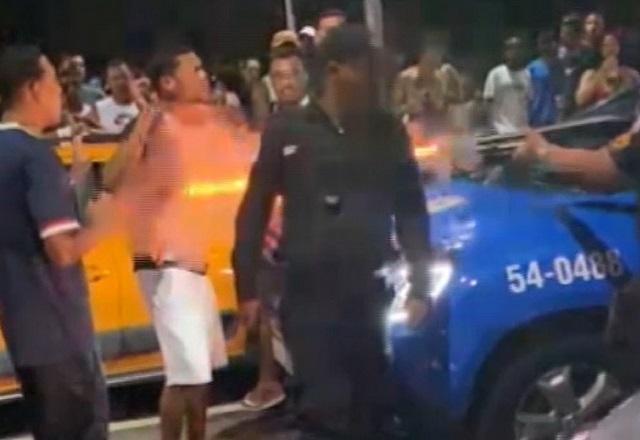 Policial militar disparando bala de borracha à queima roupa e curta distância contra homem na rua