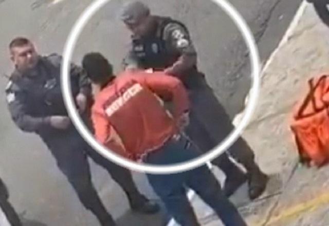 Policial militar fardado rasgando documento de trabalhador durante abordagem a motoboy