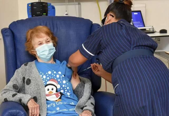 Margaret Keenan, de 90 anos, é a primeira paciente no Reino Unido a receber a vacina Pfizer-BioNTech contra a covid-19, administrada pela enfermeira May Parsons no University Hospital, Coventry, Inglaterra Foto: Jacob King / Pool via AP