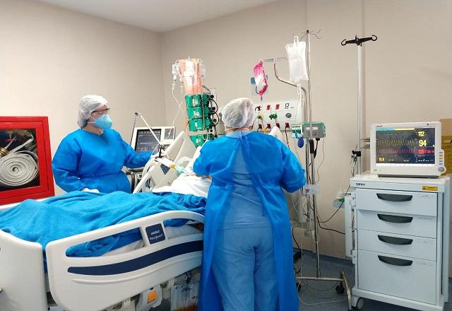 Profissionais da saúde atendem paciente deitado em cama, em leito hospitalar (Divulgação/Prefeitura de Maricá)
