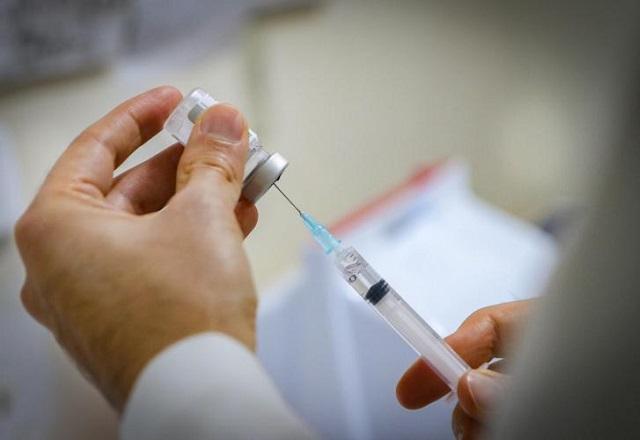 Profissional da saúde insere agulha de seringa em frasco contendo dose de vacina (Alex Rocha/Prefeitura de Porto Alegre)