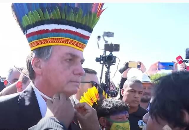 Presidente Bolsonaro recebendo cocar de indígenas na rampa do Planalto