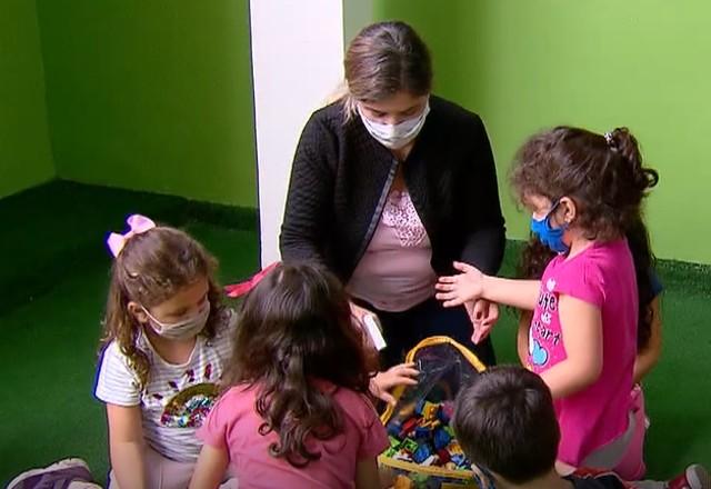 Professora e alunos interagem em escola