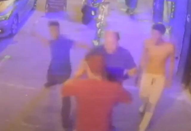 Rapaz com espada atacando outro homem durante briga em calçada, durante a noite