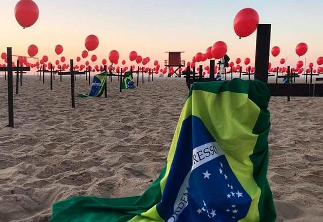 Homenagem feita em praia pela ONG Rio da Paz, com cruzes, bandeiras do Brasil e balões vermelho, às vítimas da covid (Divulgação/Rio da Paz)