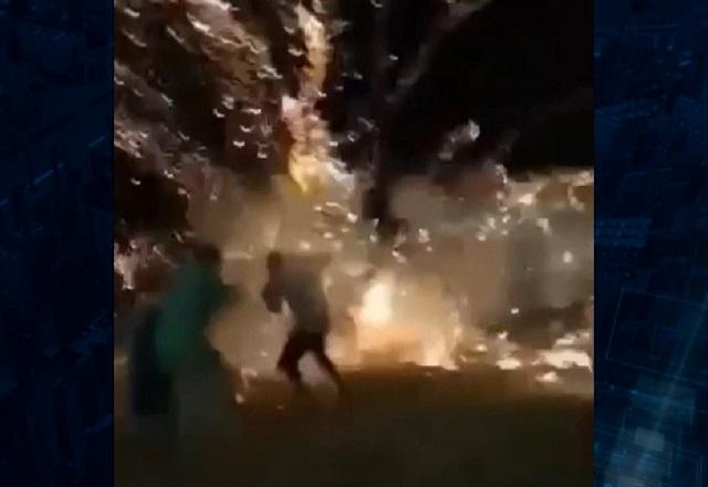 Rojão explodindo em altura baixa, no corpo das pessoas, em faixa de areia, durante a noite