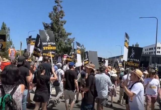 Roteiristas seguram cartazes com o nome do Sindicato dos Atores de Hollywood enquanto protestam em frente a estúdio