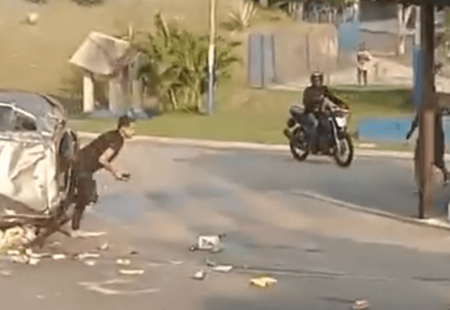 Motorista que passava pelo local registrou momento em que suspeito sai armado de veículo capotado | Reprodução/Redes sociais