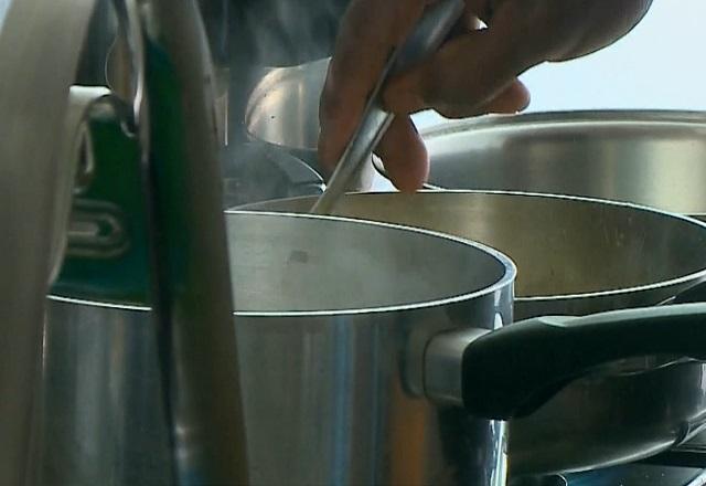 Pessoa mexe, com colher, alimento em panela (Reprodução/SBT Brasil)