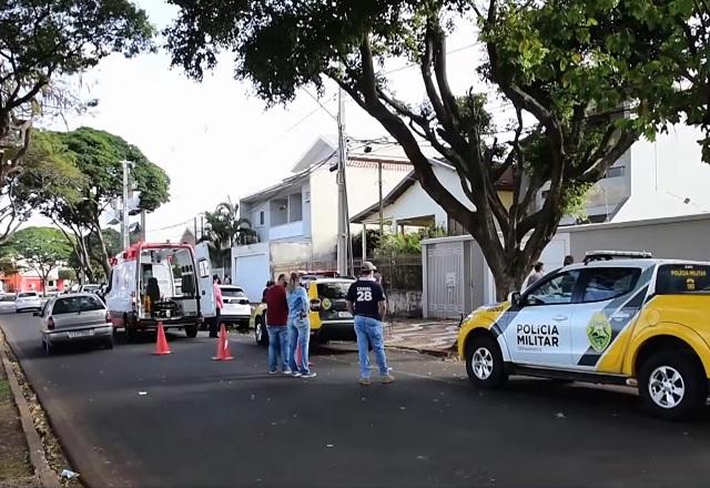 Próximo a viatura da Polícia Militar, pessoas observam casa onde assassinatos foram praticados (Reprodução/SBT Brasil)