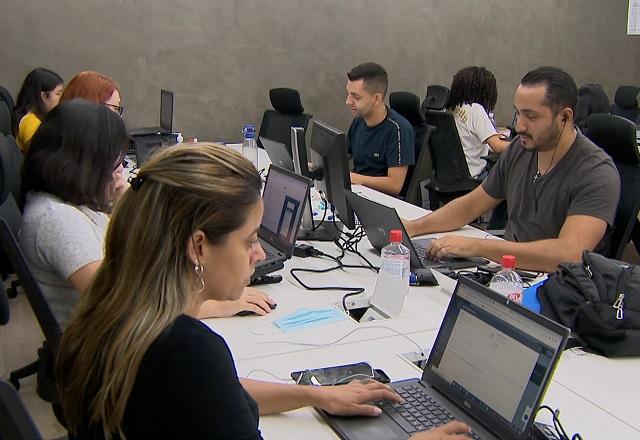 Pessoas trabalham com computador (Reprodução/SBT Brasil)