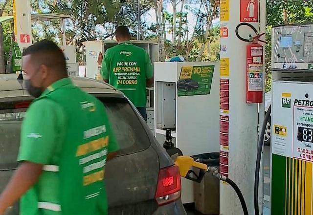 Frentista passa atrás de carro que está abastecendo em posto de combustíveis (Reprodução/SBT Brasil)