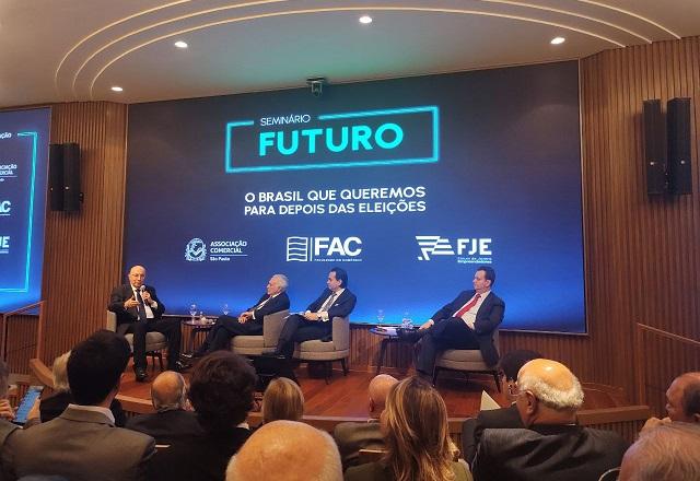 Henrique Meirelles fala ao microfone, em seminário (Guilherme Resck/SBT News)