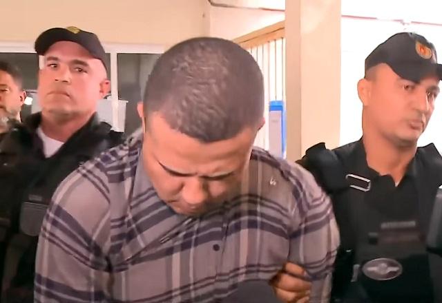 Bruno de Souza Rodrigues sendo conduzido por agentes (Reprodução/SBT)
