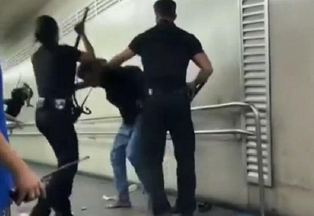 Seguranças fardados espancando homem em corredor de estação de metrô