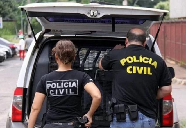 Agentes da Polícia Civil de costas, em frente a porta-malas de viatura (Divulgação/Sinpol-DF)