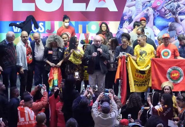 Lula fala ao microfone, ao lado de representantes de movimentos sociais e outras pessoas (Reprodução/TV PT)