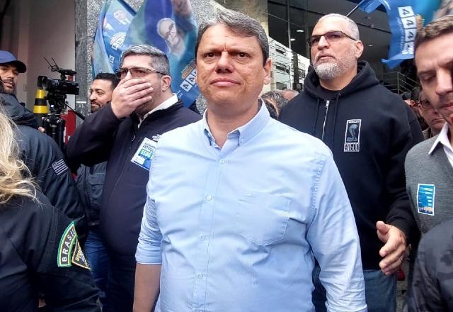 Tarcisio de Freitas de camisa azul caminhando pelo bairro do Brás