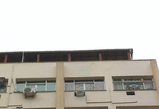 Topo de cobertura de prédio, durante o dia, filmada do térreo