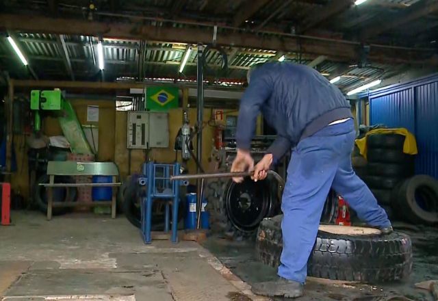 Homem troca pneu em oficina | Foto: Reprodução/SBT RS