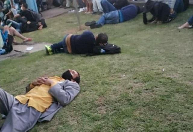 Foto de pessoas esperando atendimento deitadas em gramado de UPA (Reprodução/Twitter)