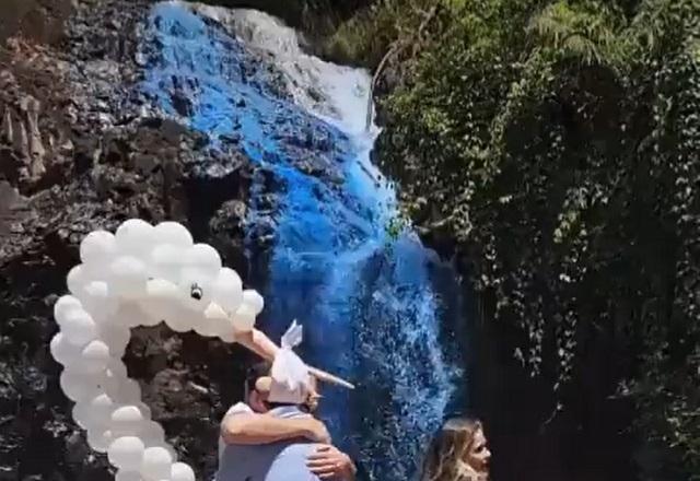 Homens e mulher à frente de cachoeira com cor azul artificial (Reprodução/Twitter)